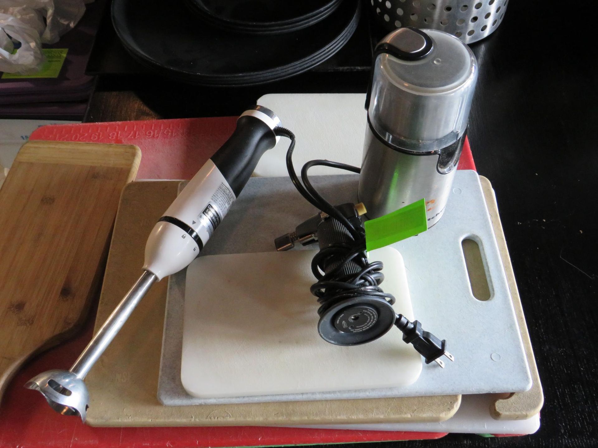 Hand blender, grinder, and cutting boards on a table.