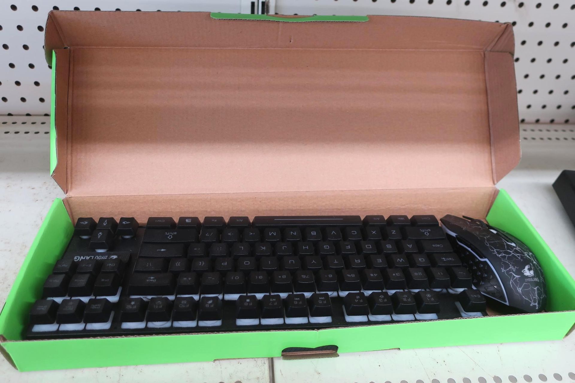 Black keyboard and mouse set in a green and brown cardboard box.
