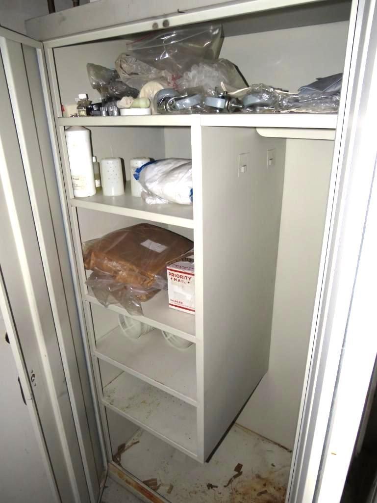 A metal storage cabinet with shelves holds various items.