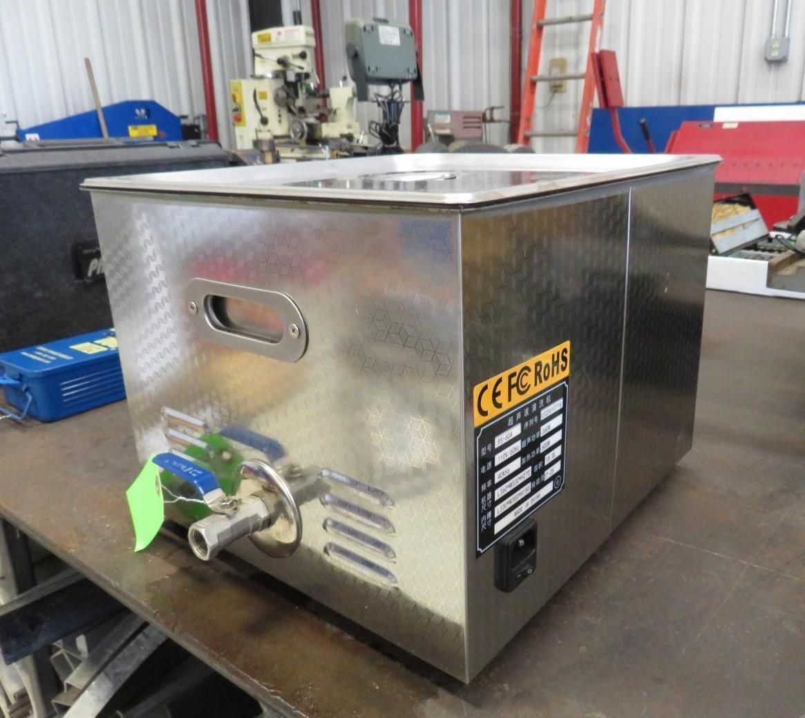Stainless steel ultrasonic cleaner with control panel and drain valve.