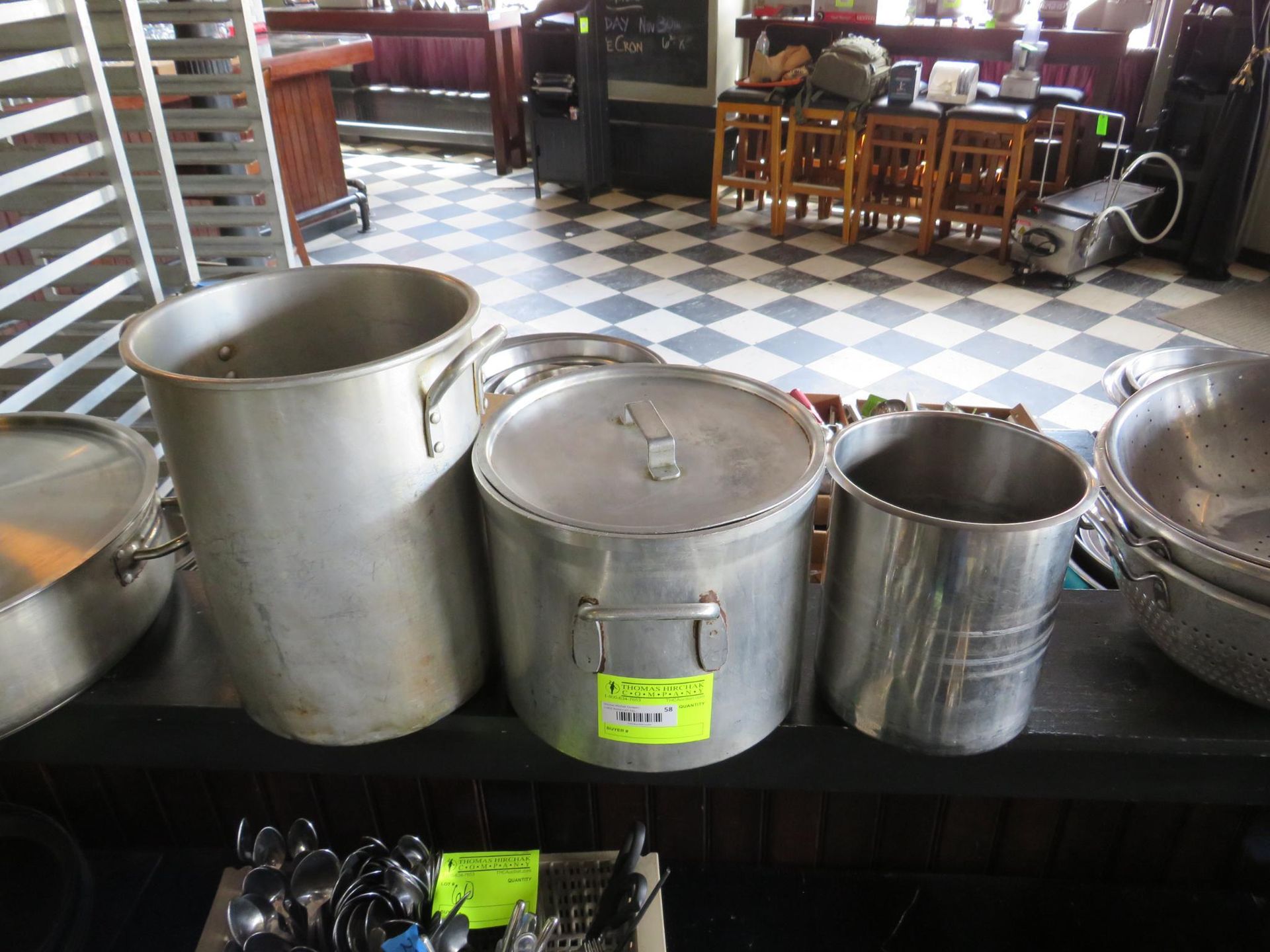 Aluminum pots of varying sizes displayed on a table.