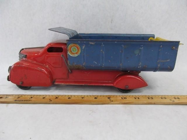Red and blue vintage tin dump truck with an open bed.
