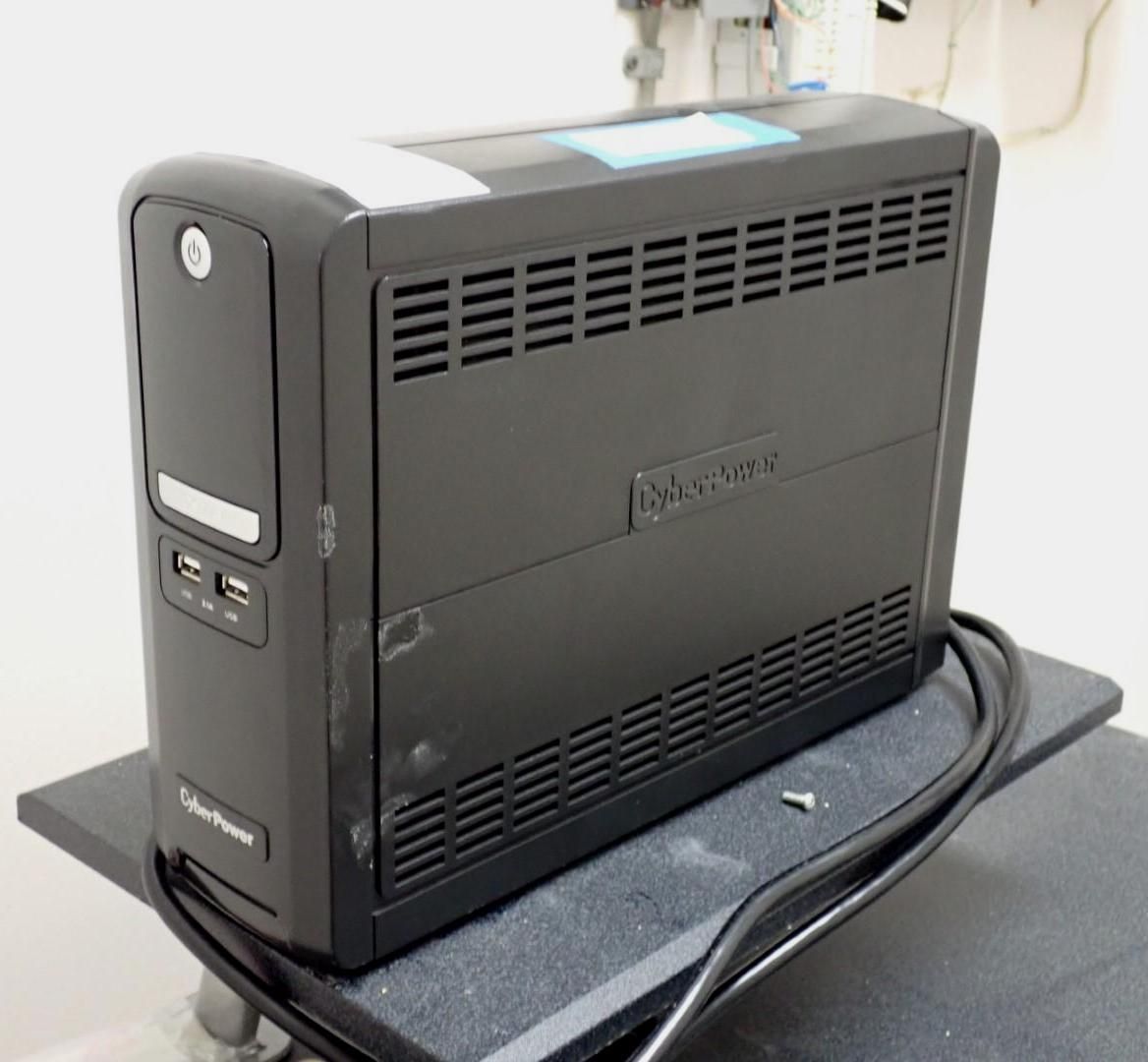 Black CyberPower uninterruptible power supply (UPS) on a black surface.