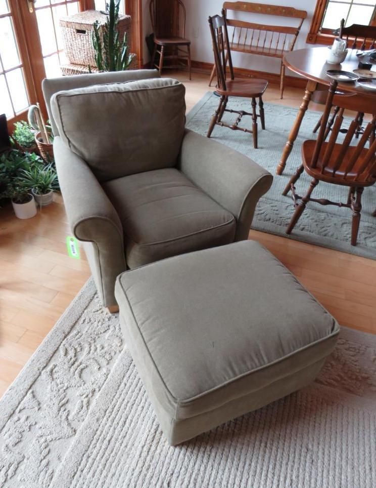 Tan armchair and ottoman on a patterned rug.