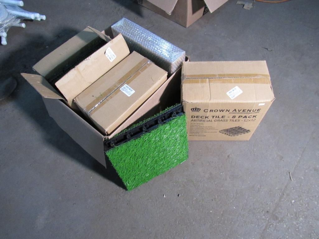 Cardboard boxes and a patch of green turf sit on a concrete floor.