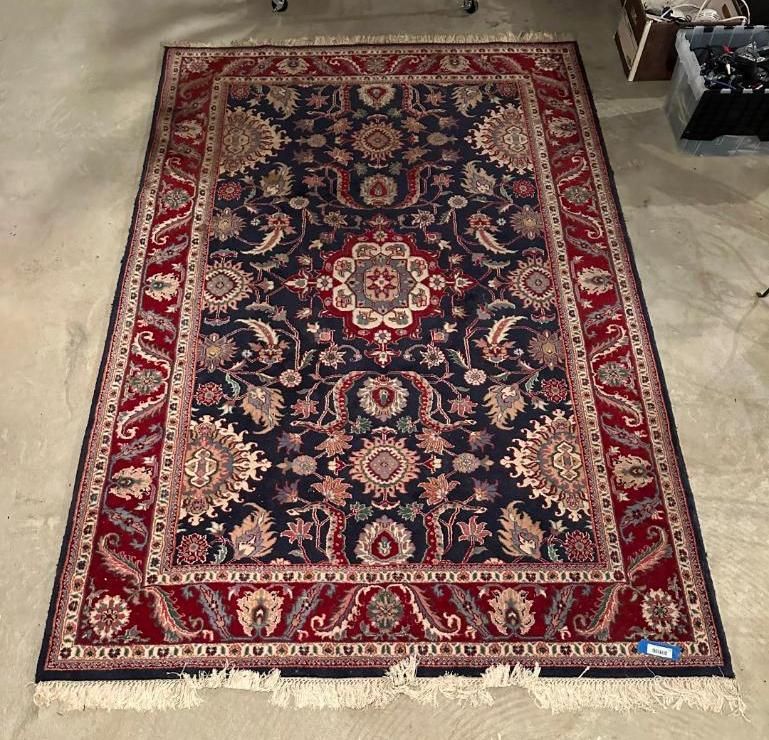 Dark blue and red ornate rug with floral and medallion patterns.