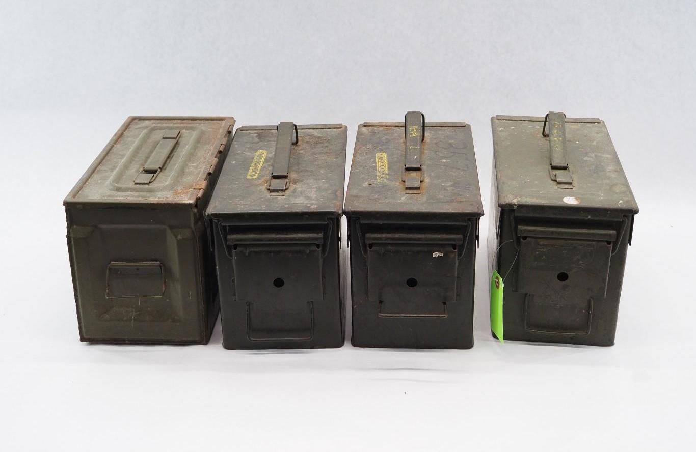 Four vintage military-style green metal ammo cans lined up on a white background