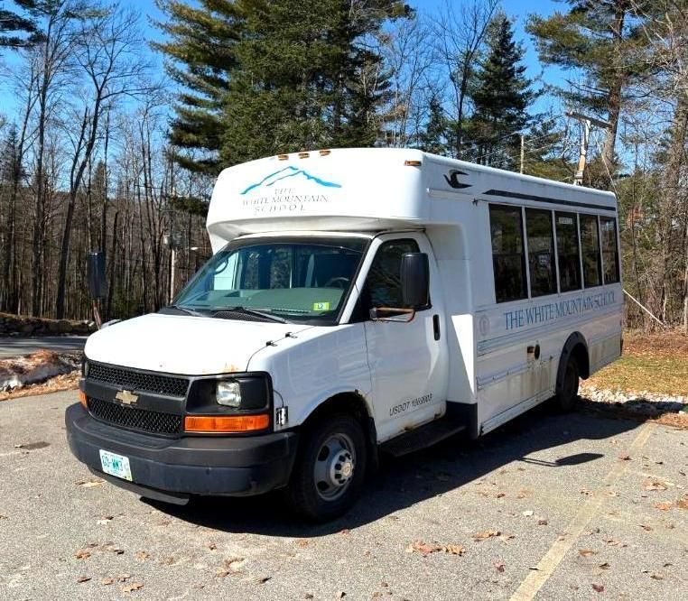 White bus parked outdoors.