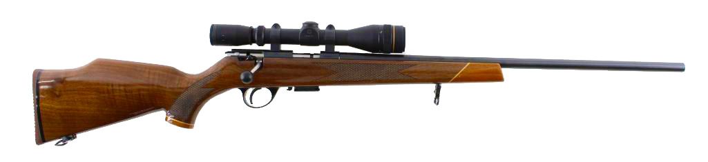 A rifle with a scope, featuring a brown wooden stock and a black barrel, against a white background.