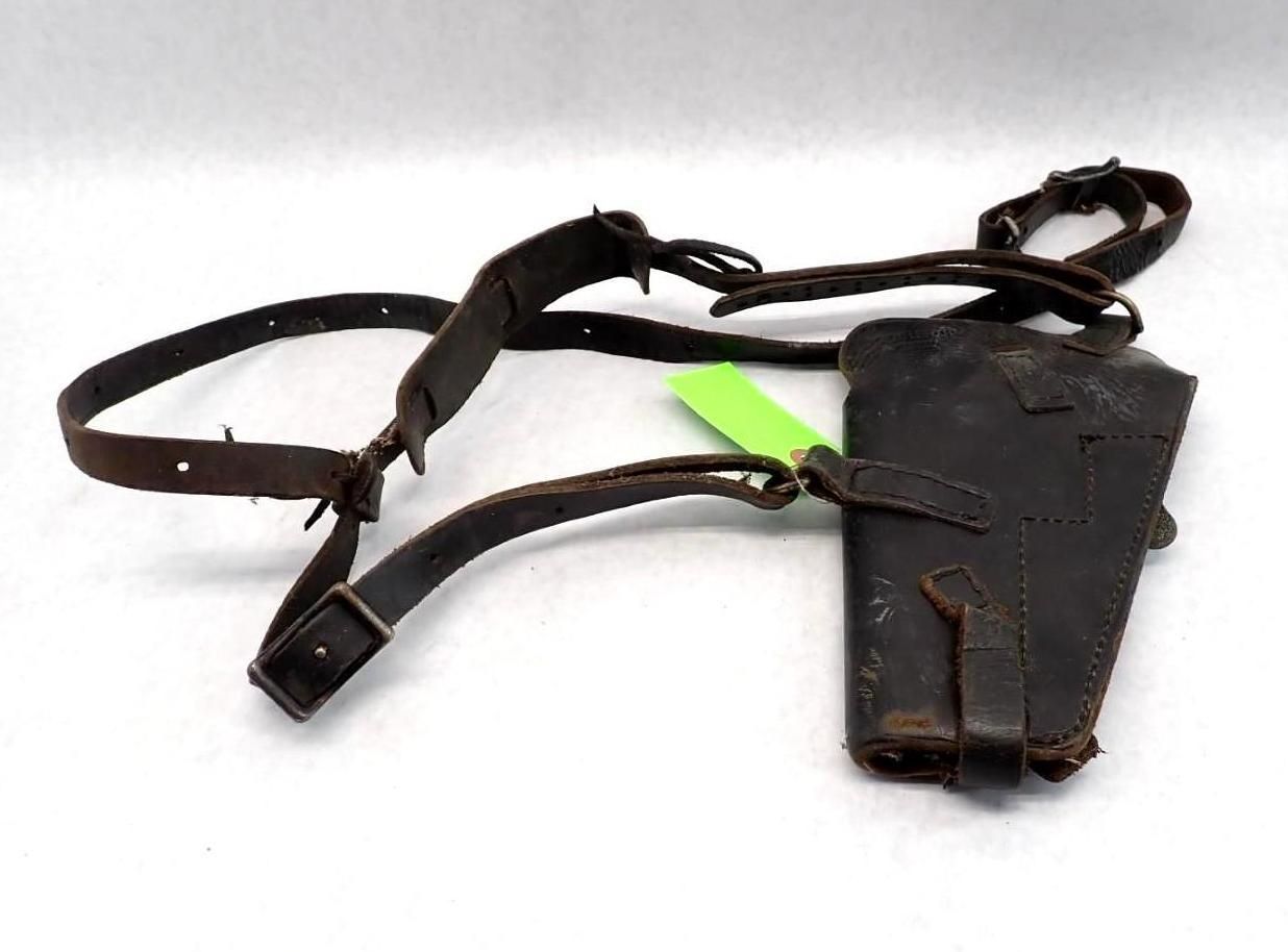 Dark leather shoulder holster with straps and a single pouch.