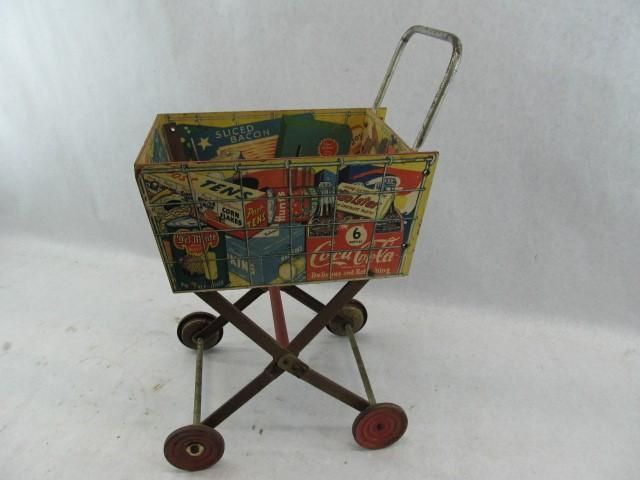 Vintage toy shopping cart with colorful advertising on its sides and red wheels.