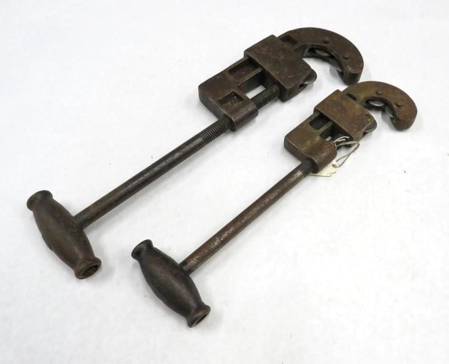 Two pipe wrenches on a white surface.