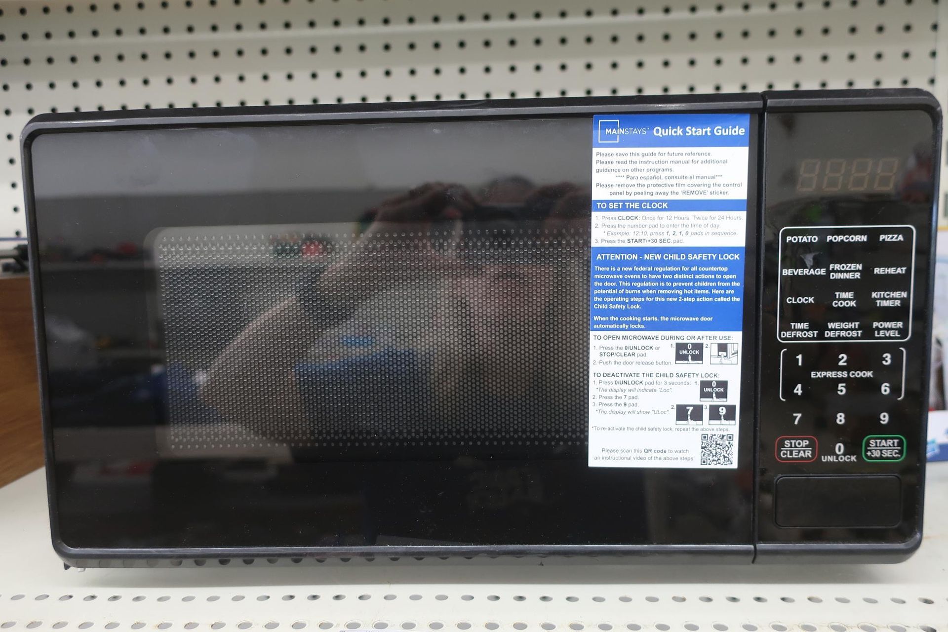 Black microwave oven with control panel and blue label.