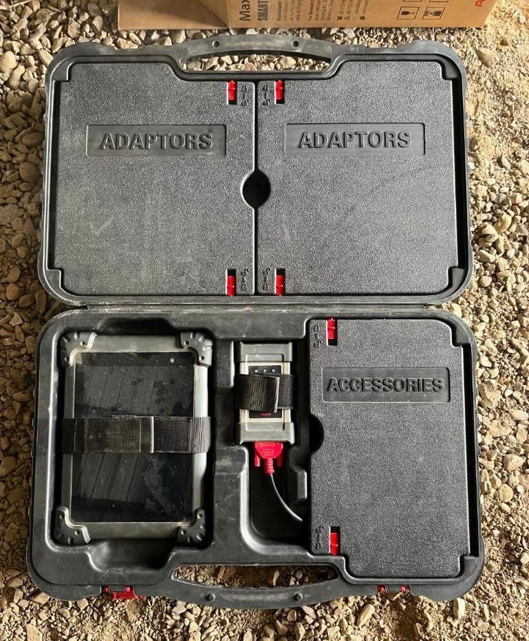 Open black tool case with compartments containing adaptors, and accessories.