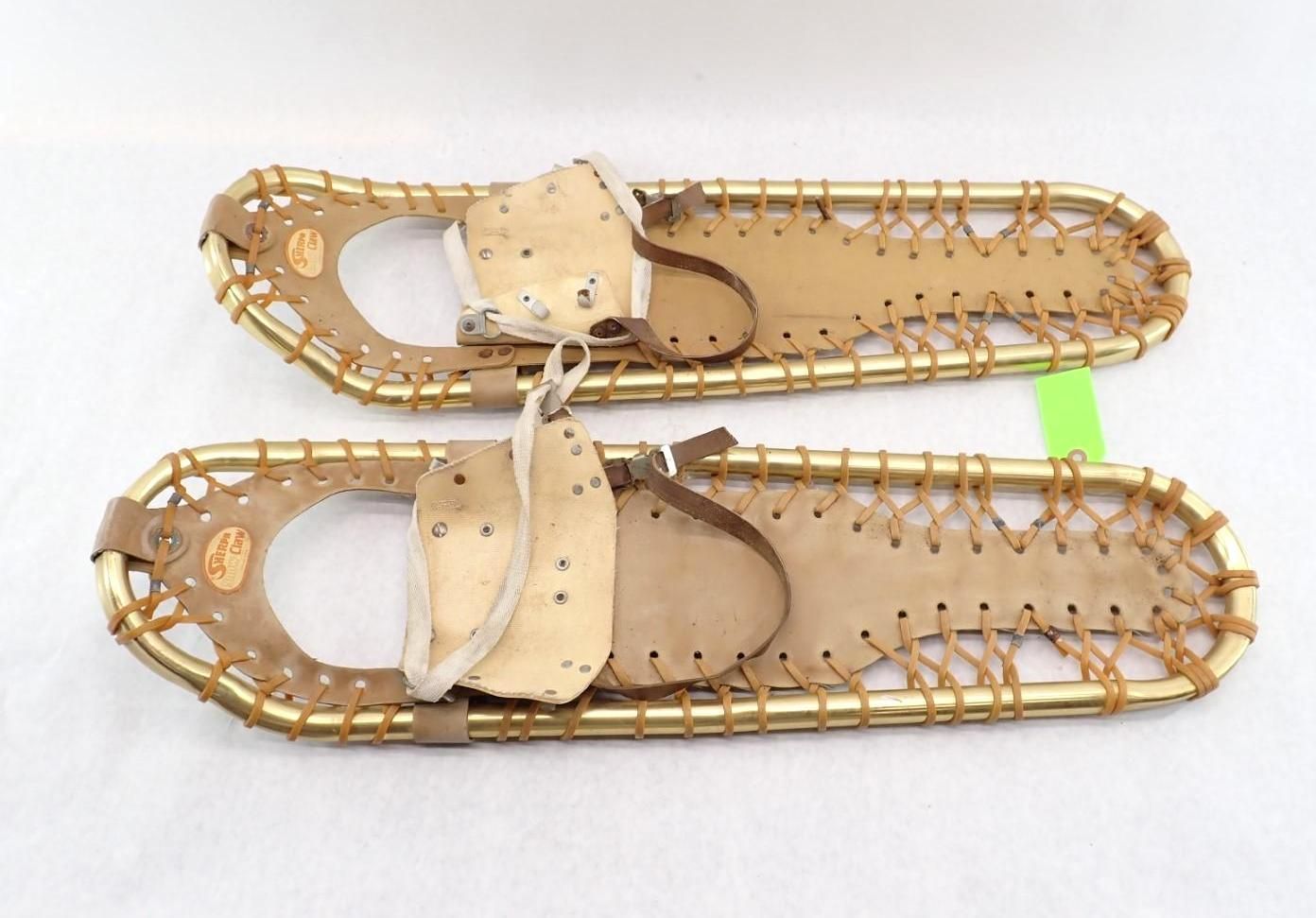 Two vintage snowshoes with wooden frames and leather bindings.
