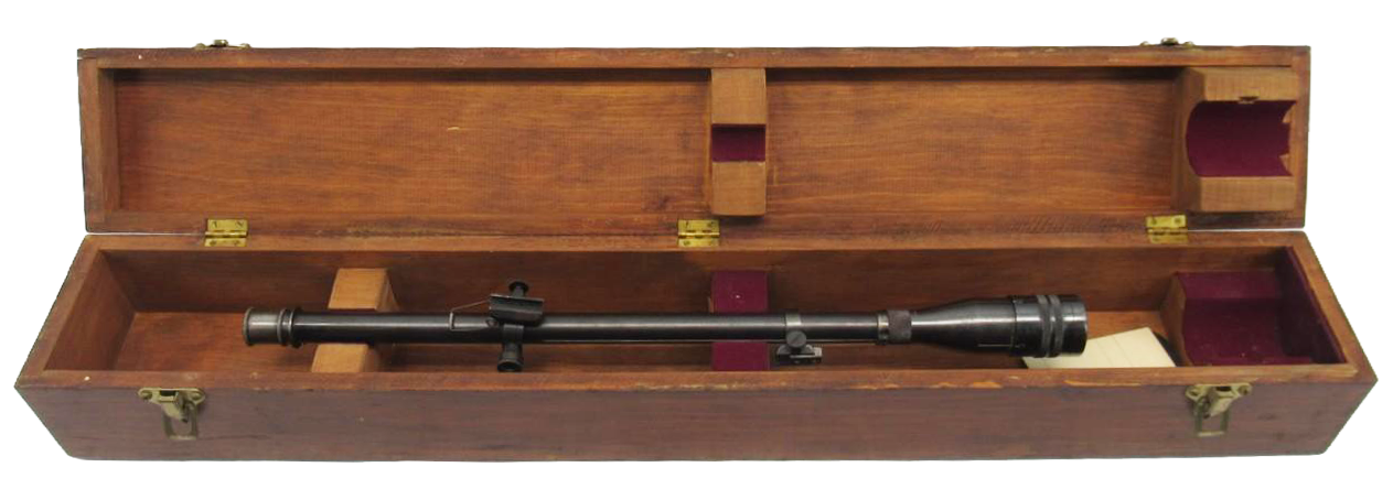 A scoped rifle inside an open wooden case.