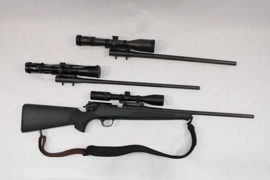 Black hunting rifle with two additional barrels and scopes.