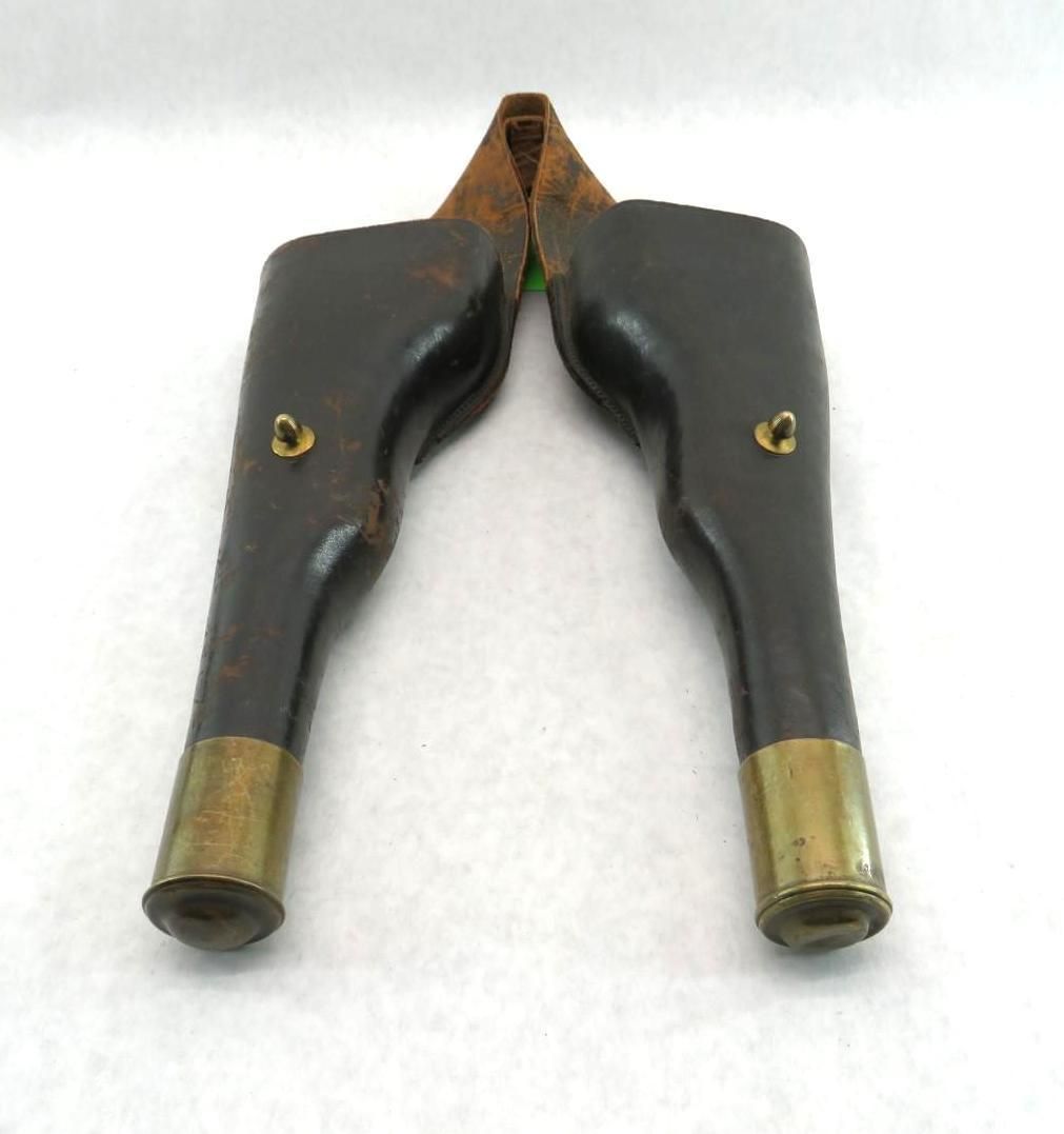 Antique leather and brass tool, brown and gold, with curved handles and cutting blades.
