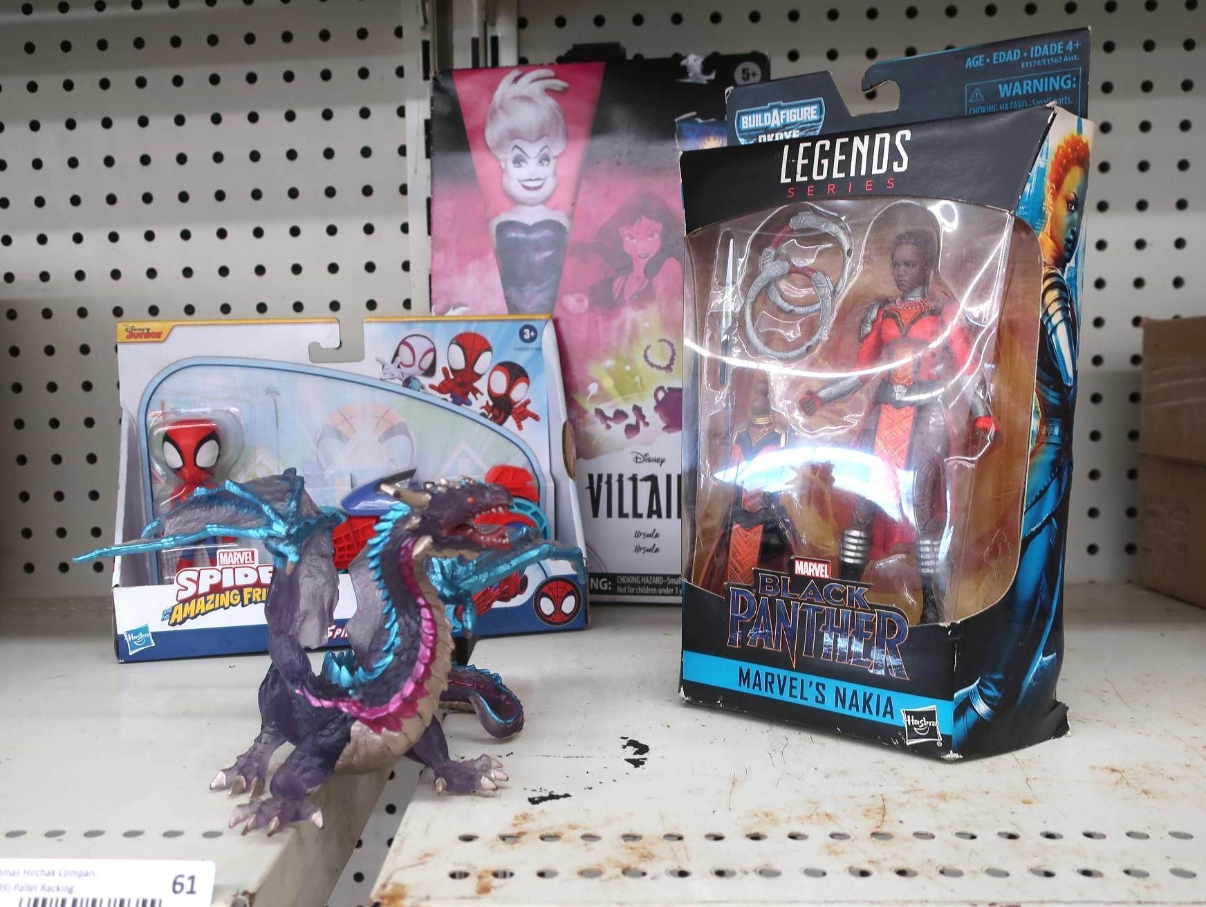 Action figures on a shelf: Spider-Man, a dragon toy, and a