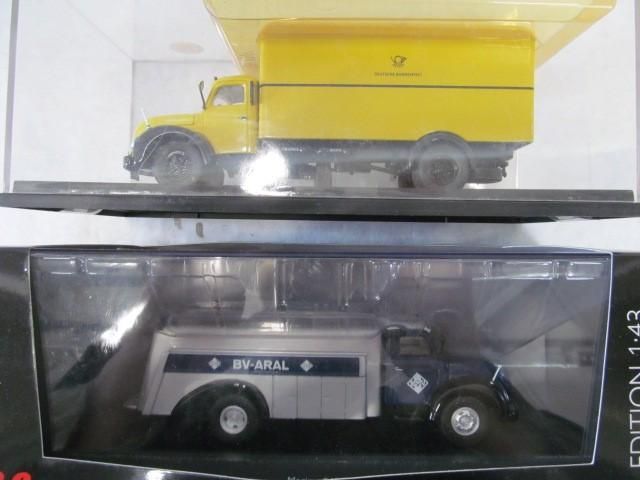 Two model trucks: a yellow postal truck and a blue and silver BV-ARAL truck, displayed in boxes.