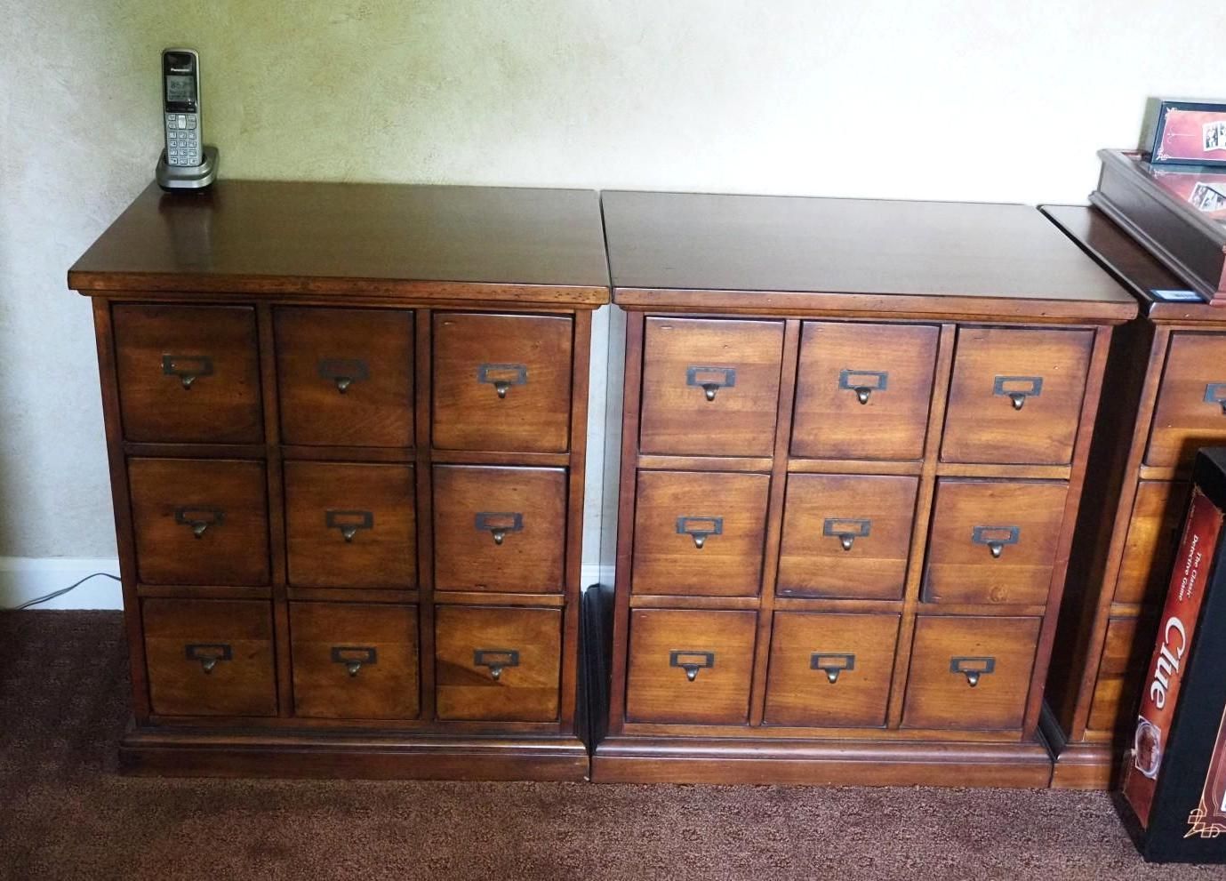 Two wooden apothecary cabinets with drawers, brown finish.