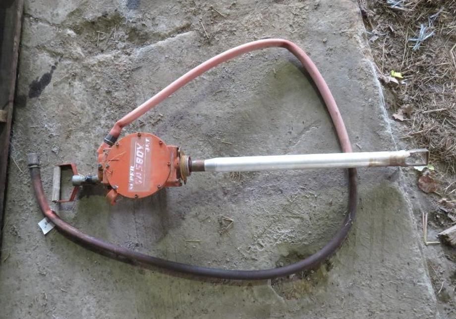 Orange pump with hoses on concrete.