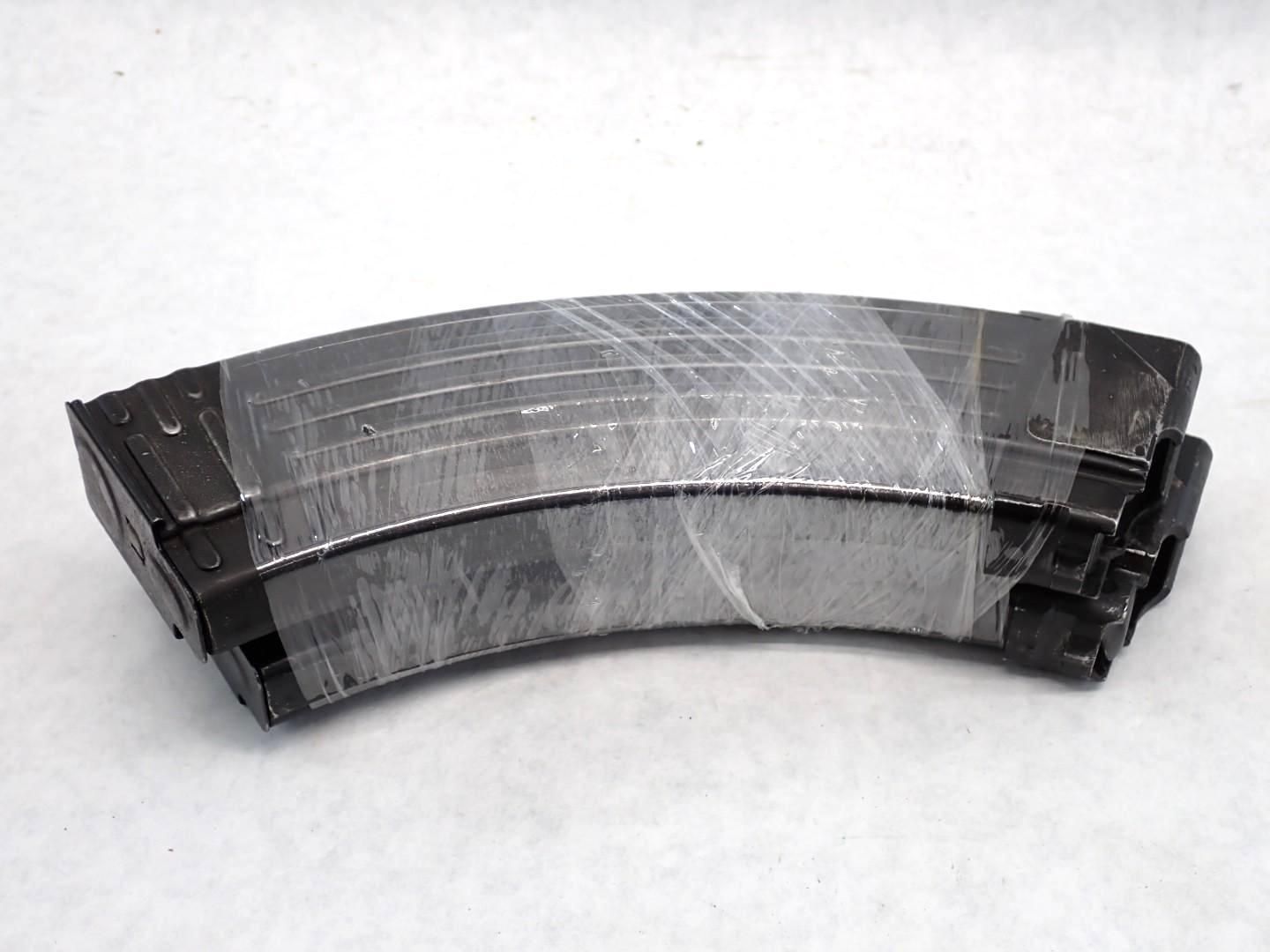 Black curved magazines wrapped in clear plastic.