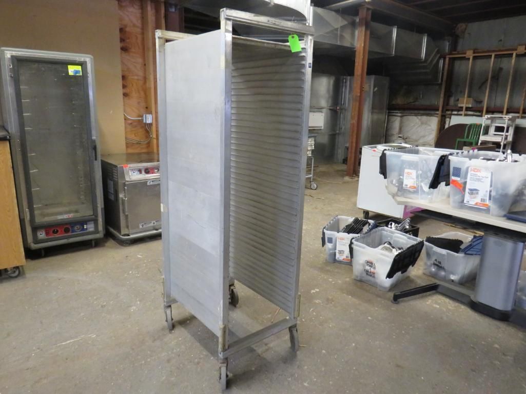 Stainless steel rack on wheels in a room.