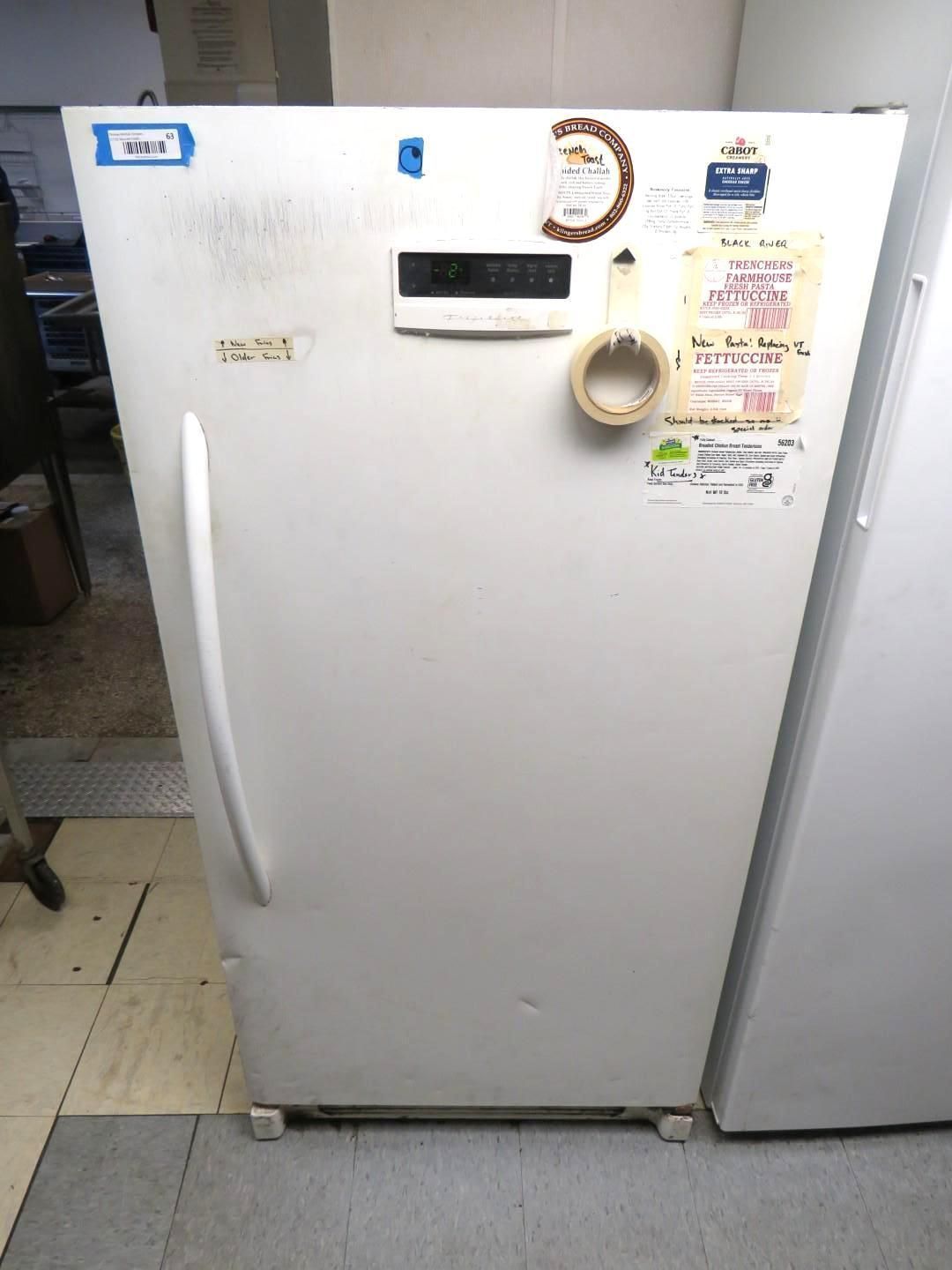 White refrigerator with handle and control panel. Stickers are on the door.