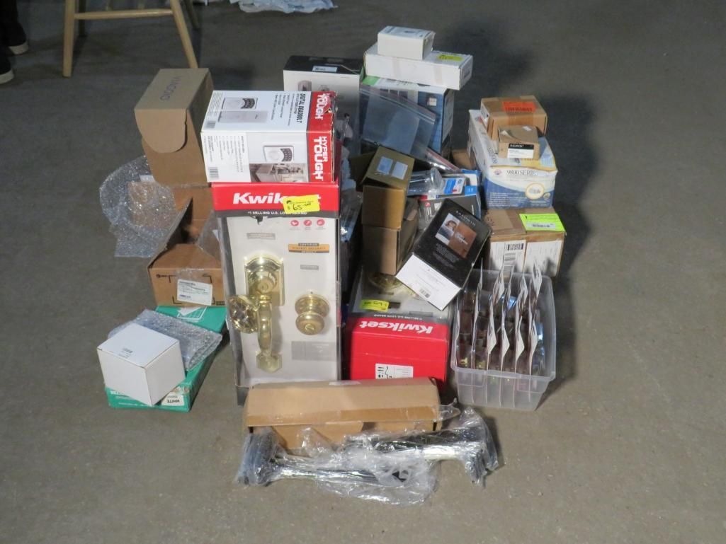 Pile of various boxes and items, likely new hardware and household goods, on a gray concrete floor.