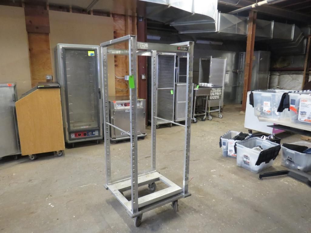 Metal food service cart with open frame in a warehouse.