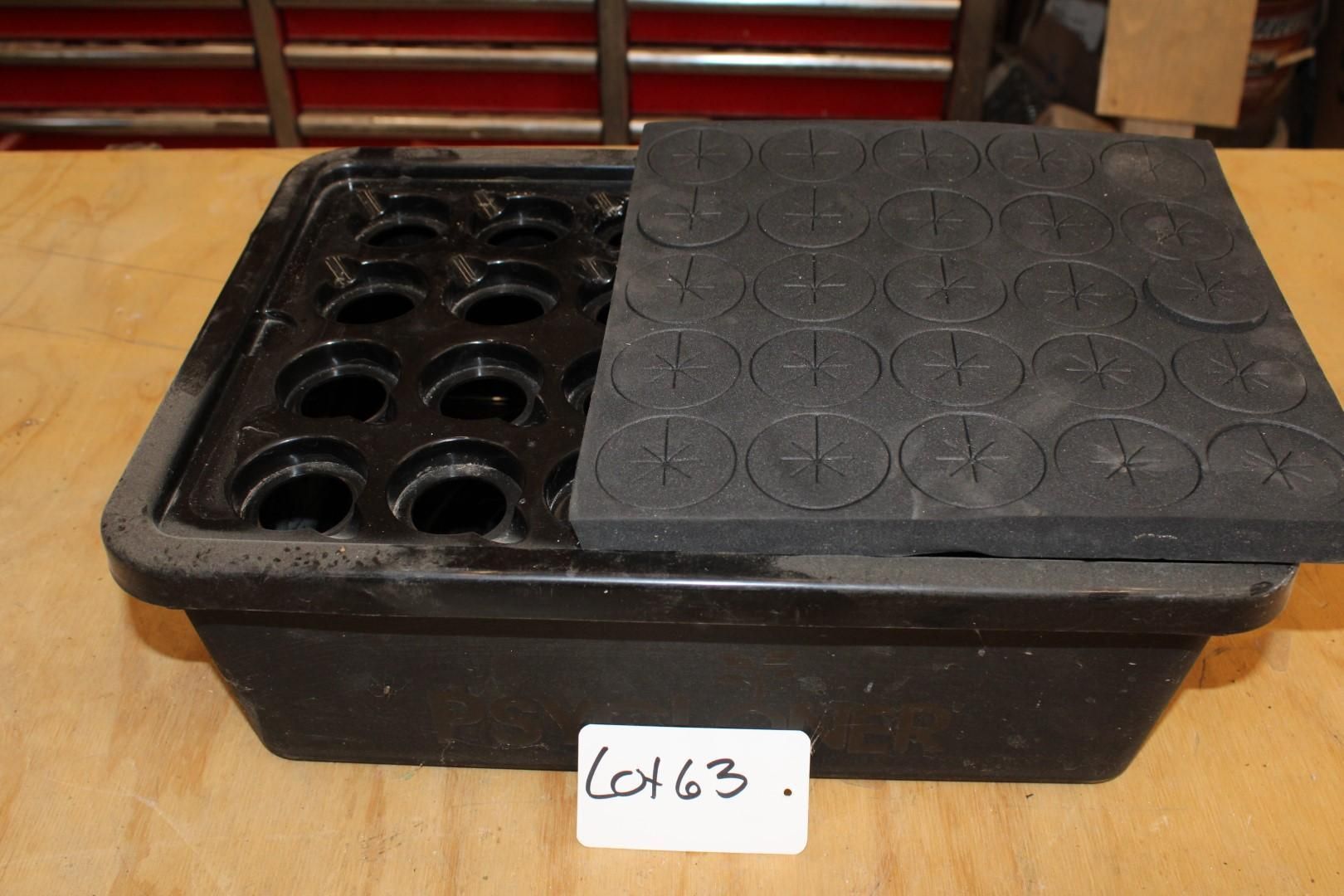 Black hydroponic system with holes and foam top, on a wooden surface.