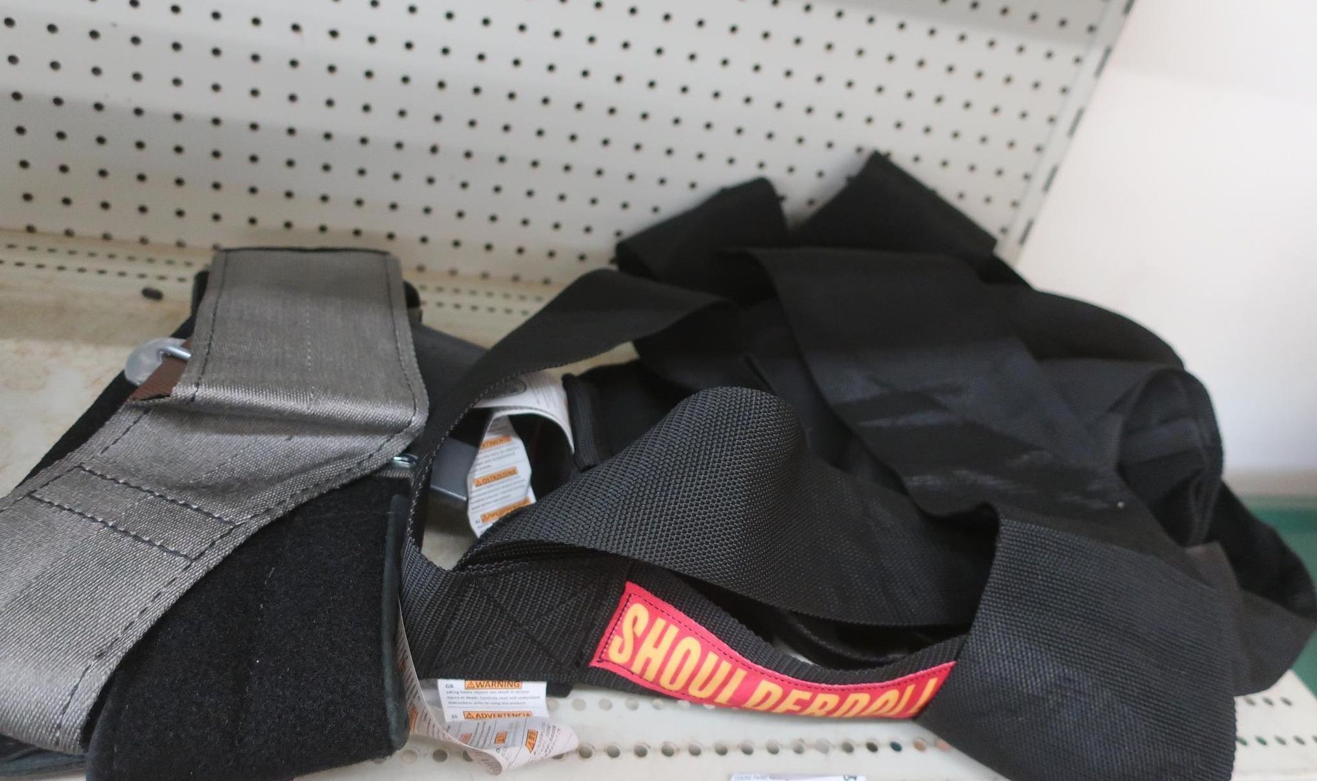 Close-up of safety harness straps, black and gray, with