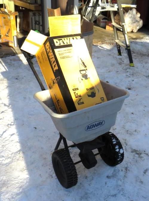 Yellow DeWalt box in a tan Agri-Fab spreader on snow.