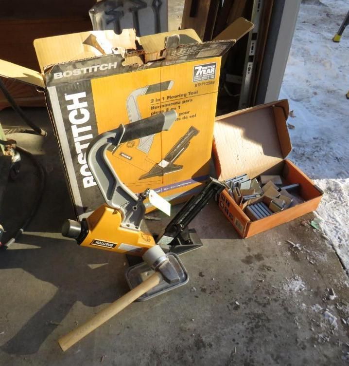 Bostitch 2-in-1 flooring stapler with box and staple box on a concrete surface.