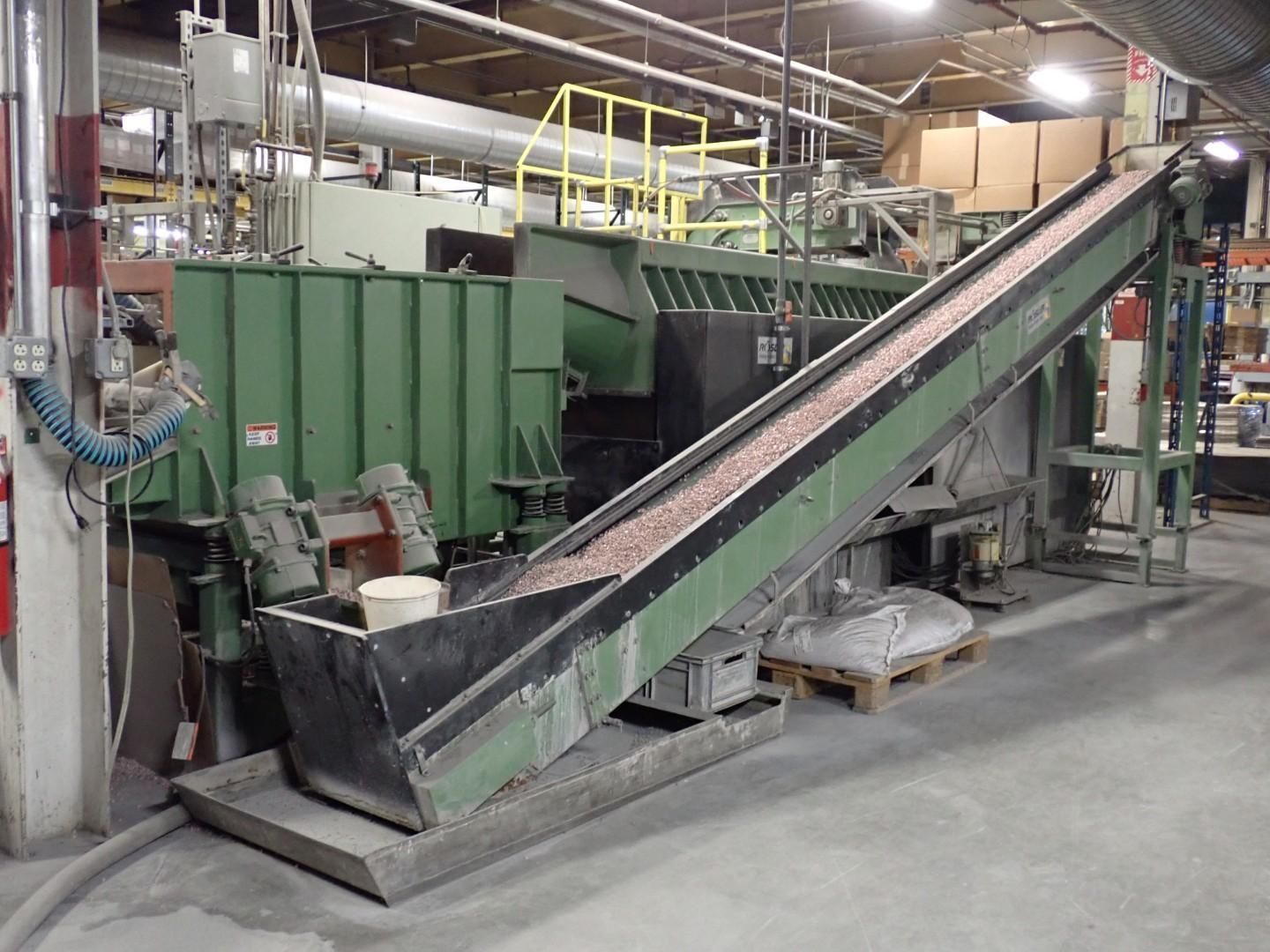 Industrial machinery, a green conveyor belt transports materials up to a large processing unit.