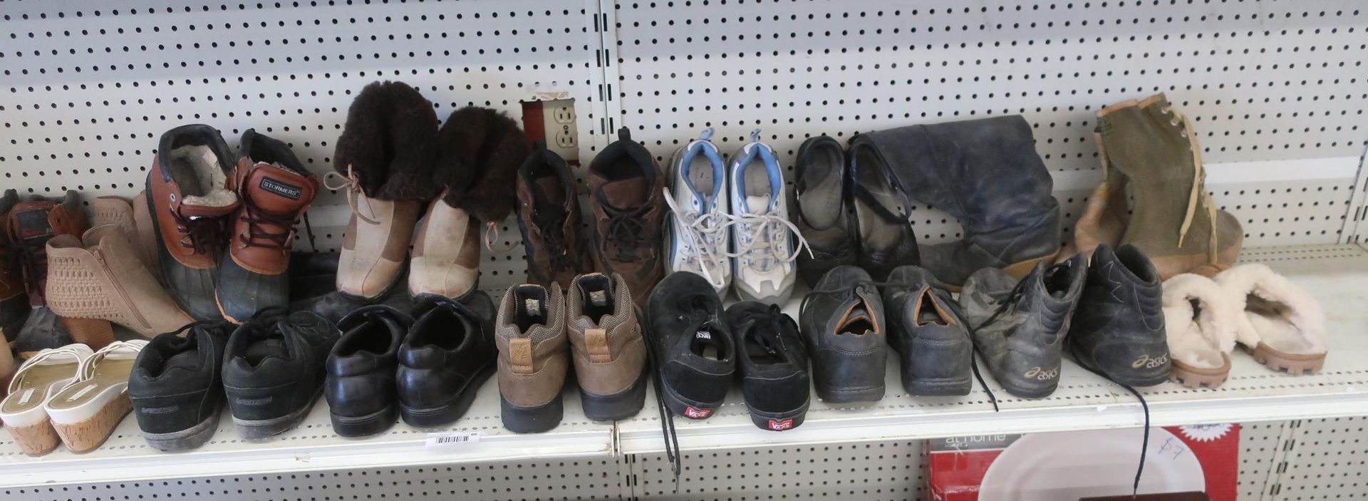 Shoes of various styles displayed on a white shelf against a white background.