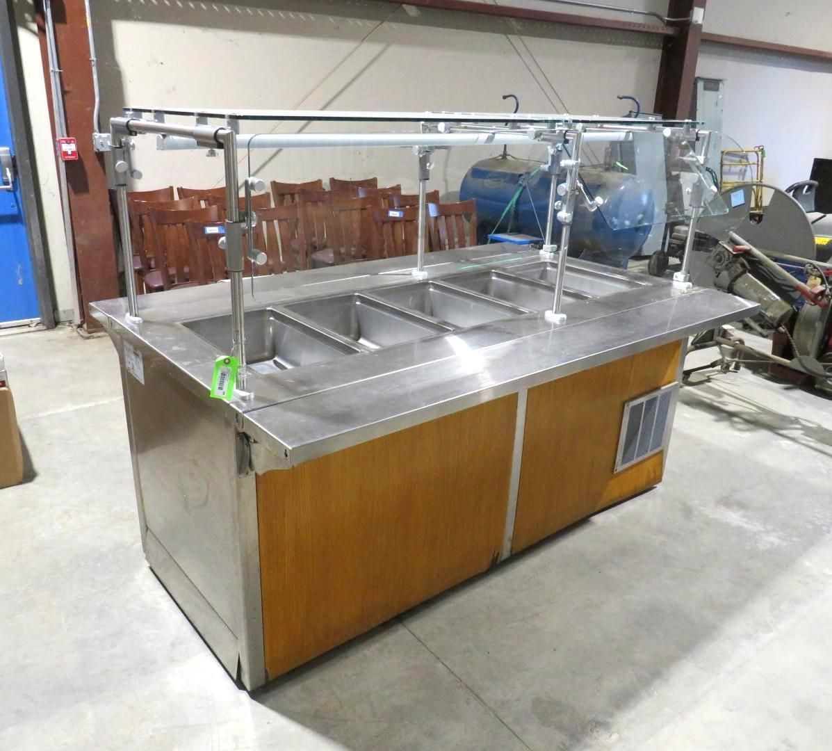 A stainless steel and wood buffet with multiple food compartments, and overhead sneeze guard.