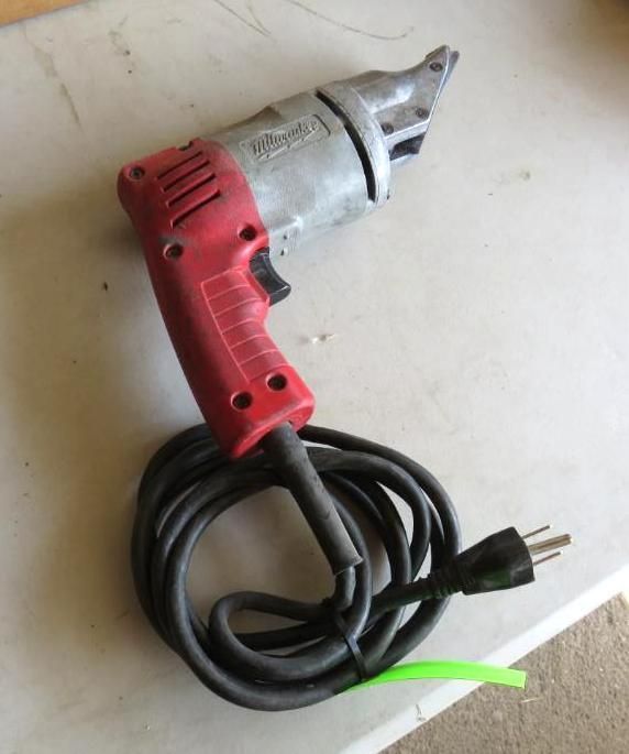 Red and silver power shear tool with a black cord and plug.