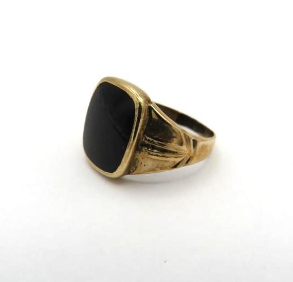 Gold ring with a square black stone.