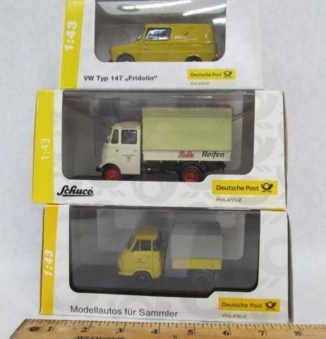 Three model Deutsche Post delivery vehicles in boxes, yellow and white, various sizes.