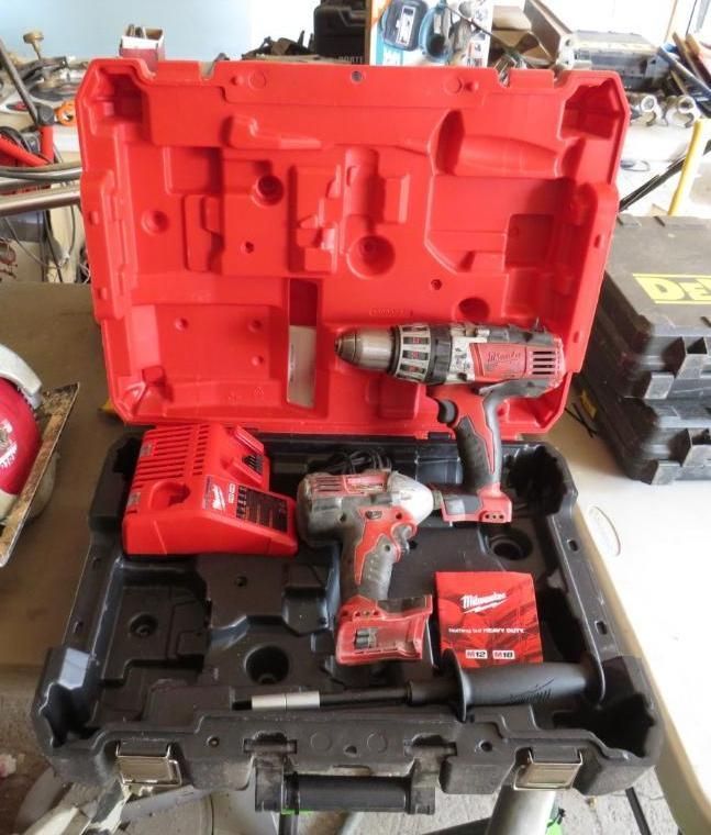 Red and black Milwaukee power tool kit, open, with drill, impact driver, and charger.