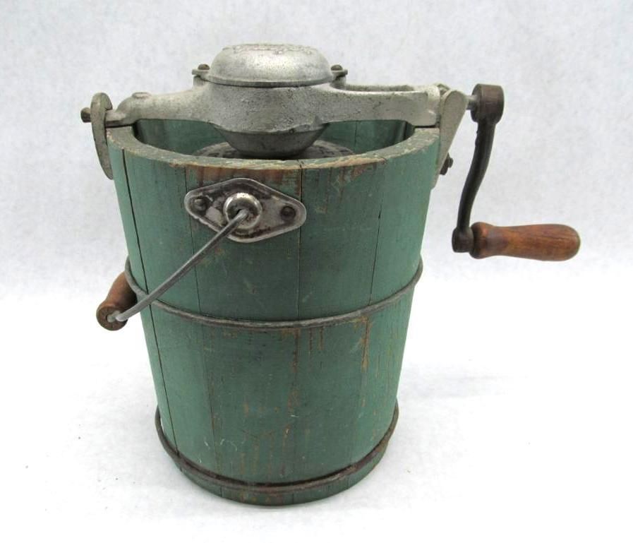 Green wooden ice cream maker with a metal top and crank handle.
