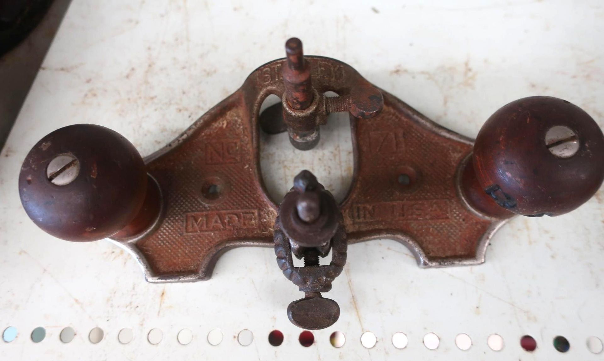 Brown metal router plane with wooden handles,