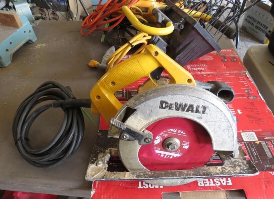 Yellow and silver DeWalt circular saw with a red blade on a cardboard surface.