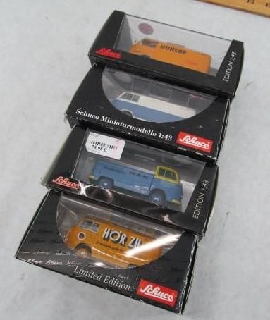 Four boxed miniature VW vans, in various colors and designs, stacked on top of each other.