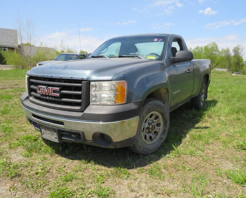 Blue GMC pickup truck parked on grass.