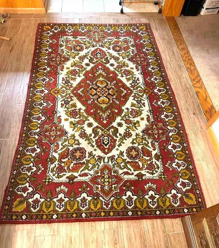 Red and white patterned rug on wood floor.
