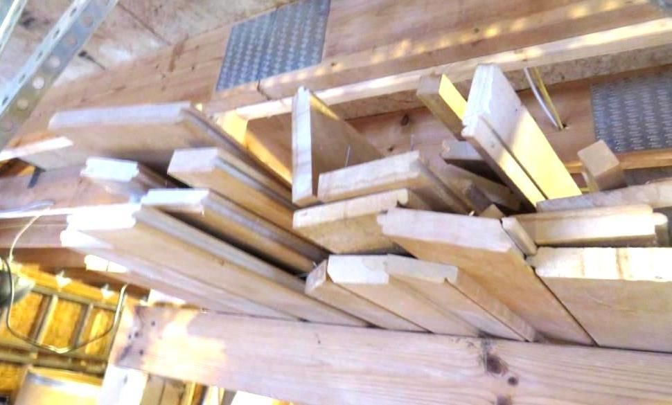 Pile of assorted wooden planks in a wooden structure.