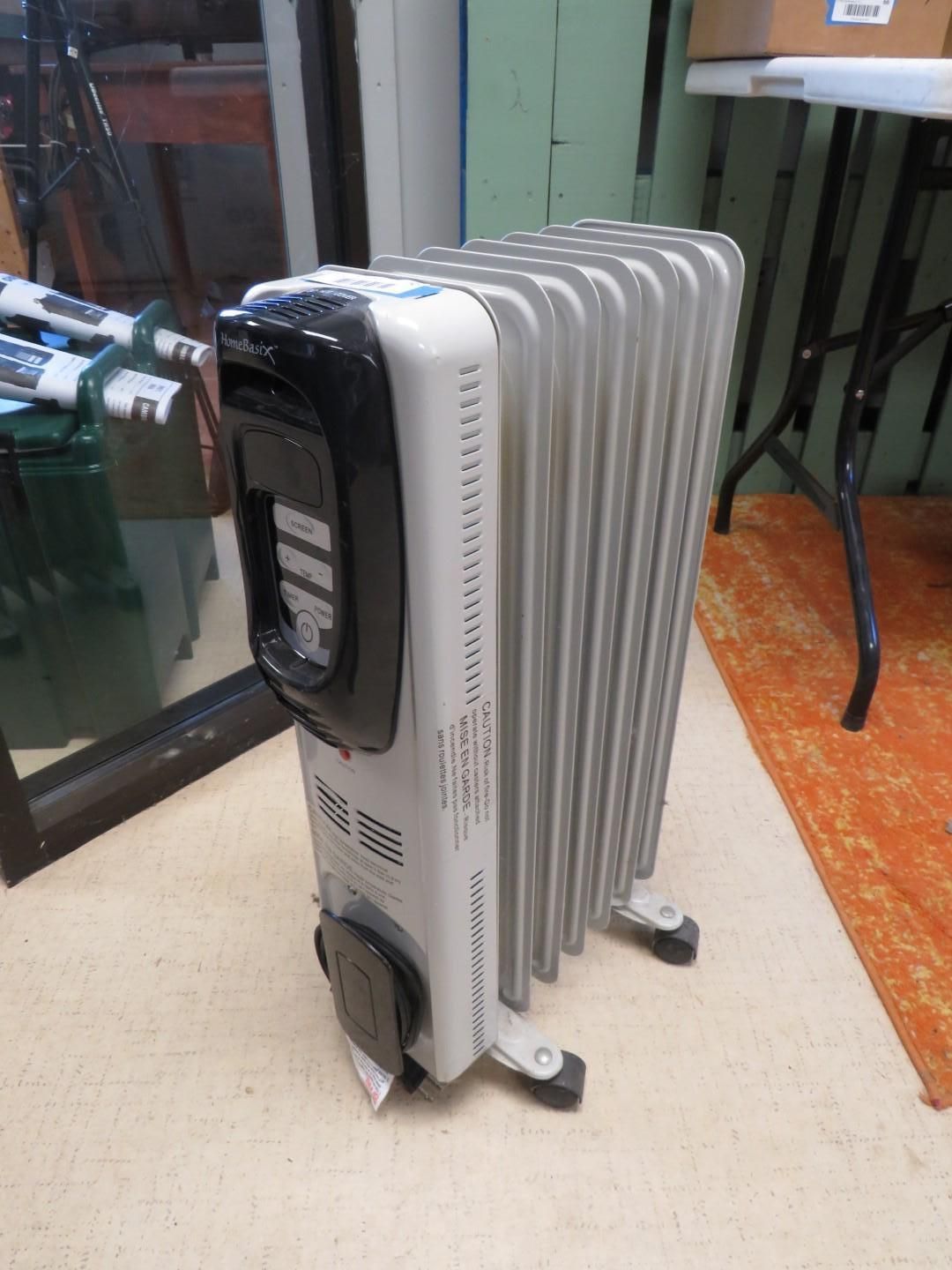 Oil-filled space heater on a floor, with a digital control panel, in a room with a rug.